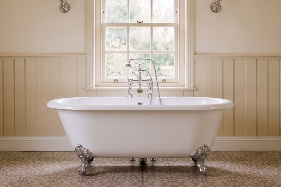 Vrijstaand bad op chromen pootjes in een klassieke badkamer
